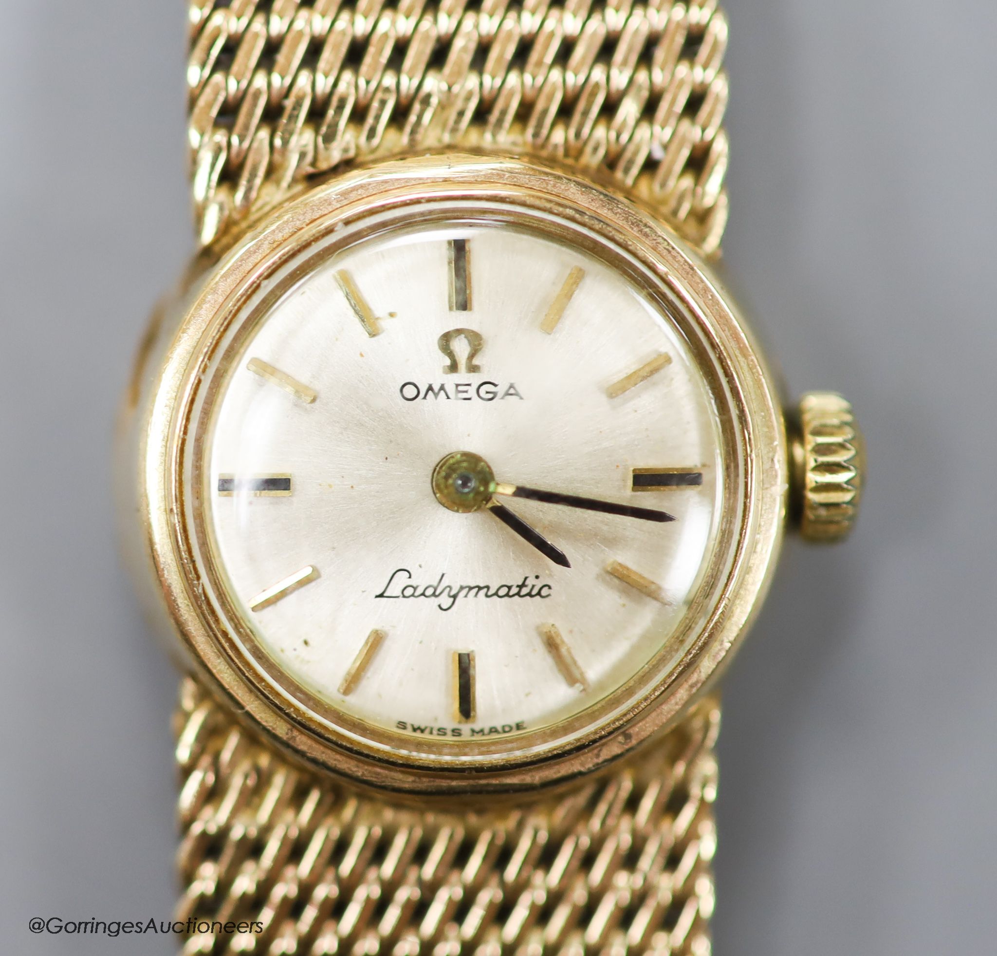 A lady's 9ct gold Omega Ladymatic wrist watch on integral 9ct gold Omega bracelet